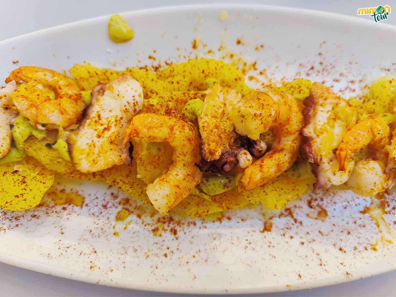 Tapa de arrieras, cama de patata, pulpo y langostinos a la plancha